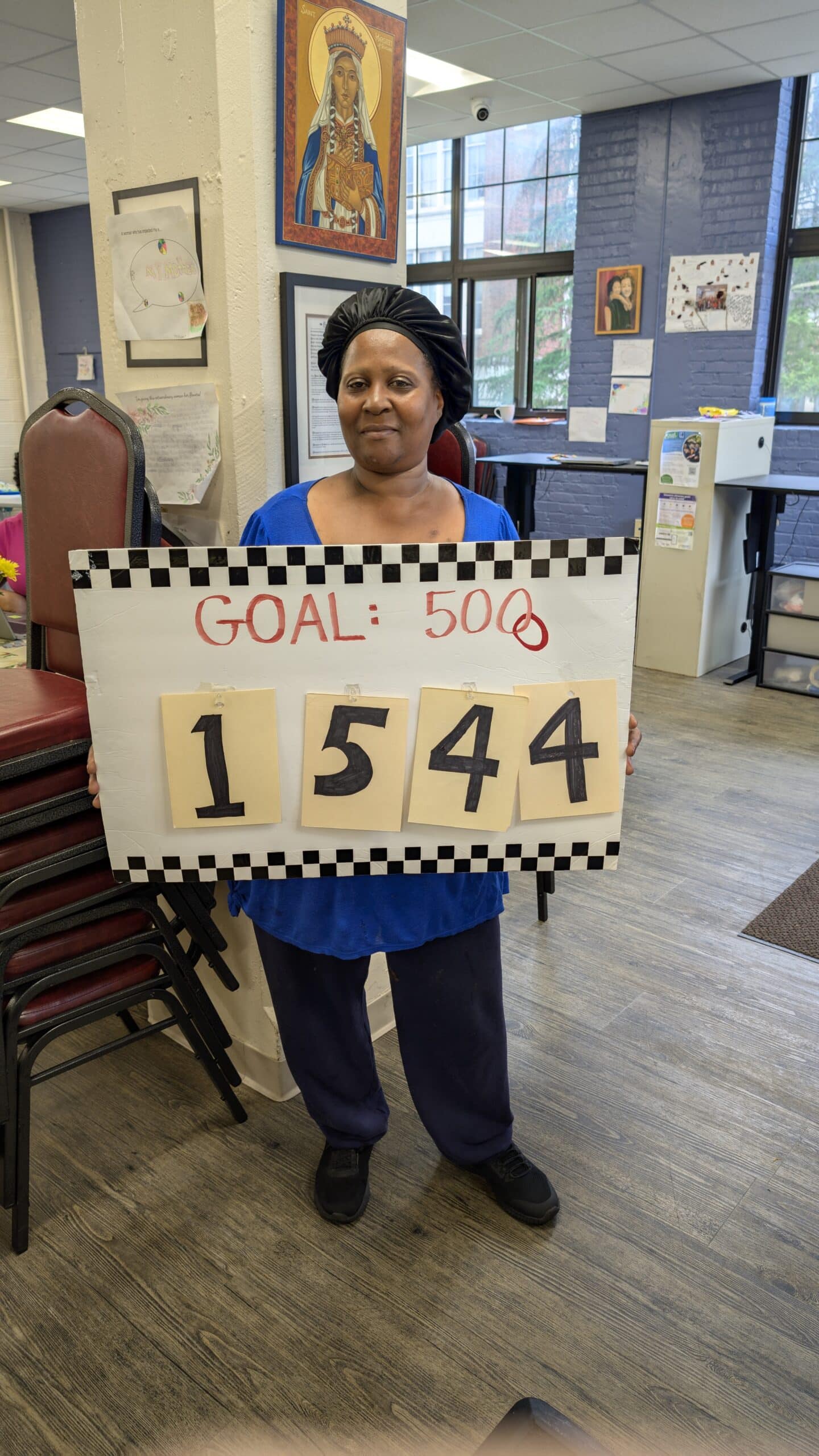 Woman holding sign that says Goal: 5000 and the number 1544
