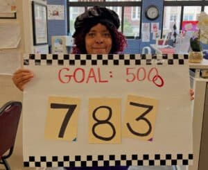 Woman holding sign that says Goal: 5000 and the number 783