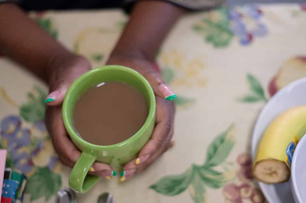 A pair of hands holding a coffee mug on a table