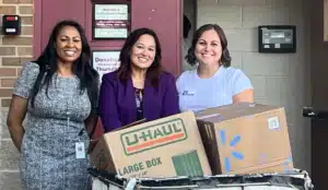 Smiling women dropping off items